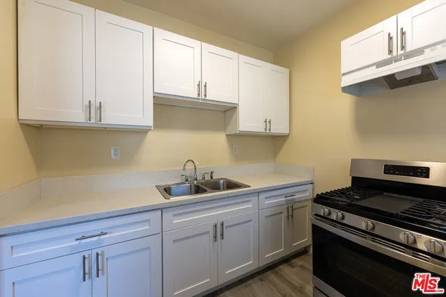 a kitchen with white cabinets and appliances