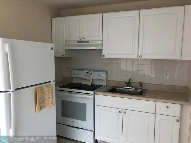 a kitchen with stainless steel appliances granite countertop white cabinets sink and a granite counter tops
