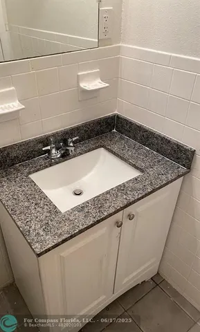 a bathroom with a granite countertop sink and a white stove
