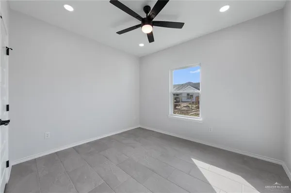 an empty room with a window and a ceiling fan