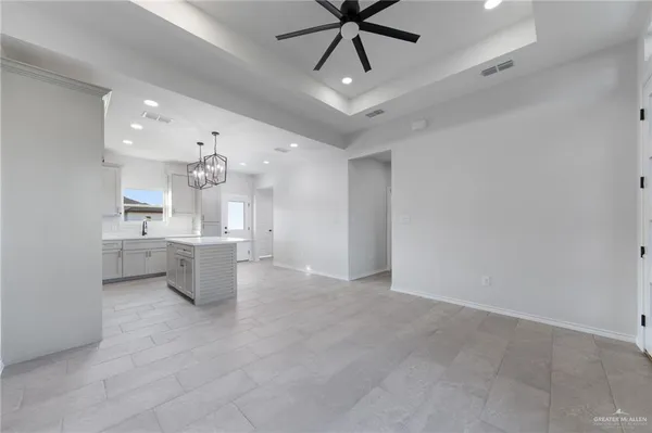 a view of a kitchen and a sink and chandelier fan