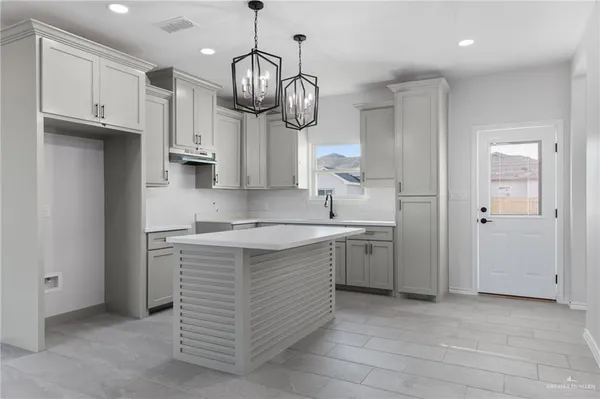 a kitchen with kitchen island granite countertop stove top oven and cabinets