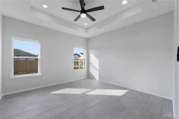 an empty room with windows and fan