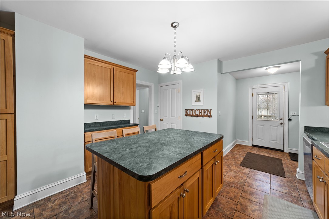 1680 Lee Road Cleveland, OH 44118 - Photo 13 of 45 Kitchen featuring a kitchen island, an inviting chandelier, pendant lighting, and dark tile floors