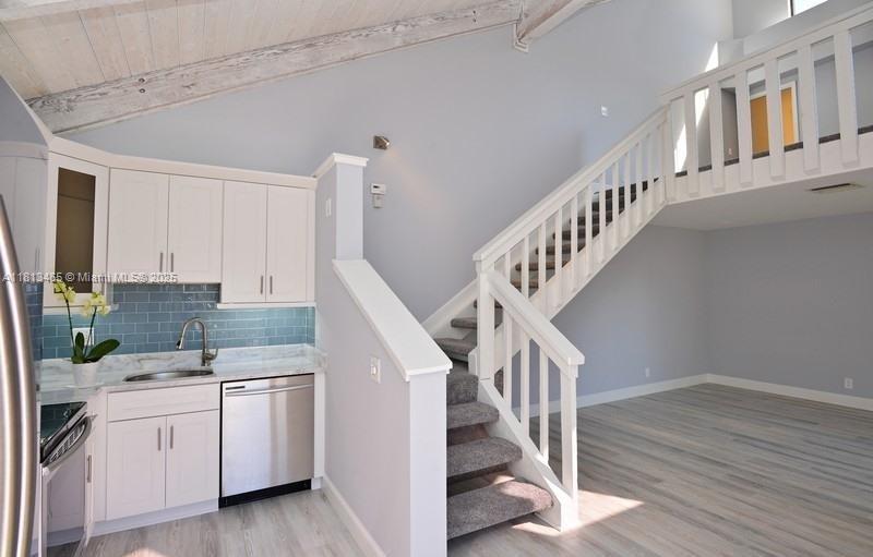 1605 Highway 1, Unit 10H Jupiter, FL 33477 - Photo 9 of 31 a kitchen with white cabinets a sink and dishwasher