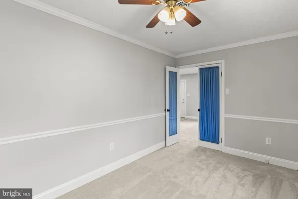 a view of an empty room with a chandelier fan