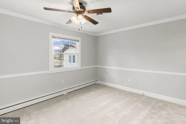 an empty room with a window and a fan