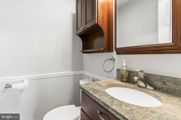 a bathroom with a granite countertop toilet sink and mirror