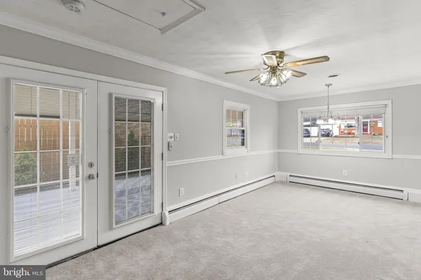 an empty room with windows and fan