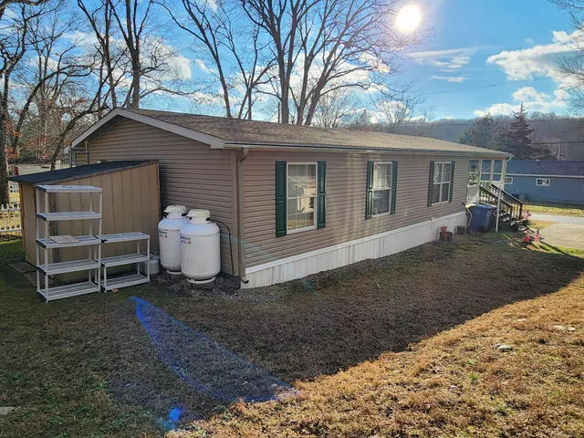 a view of a house with a yard and fence