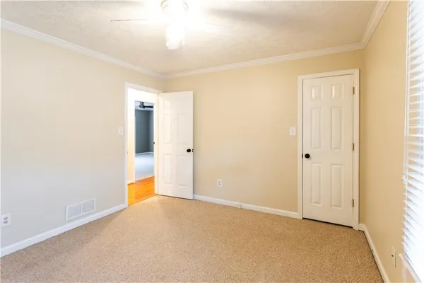 an empty room with a window and a fan