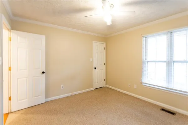 an empty room with a chandelier fan and closet