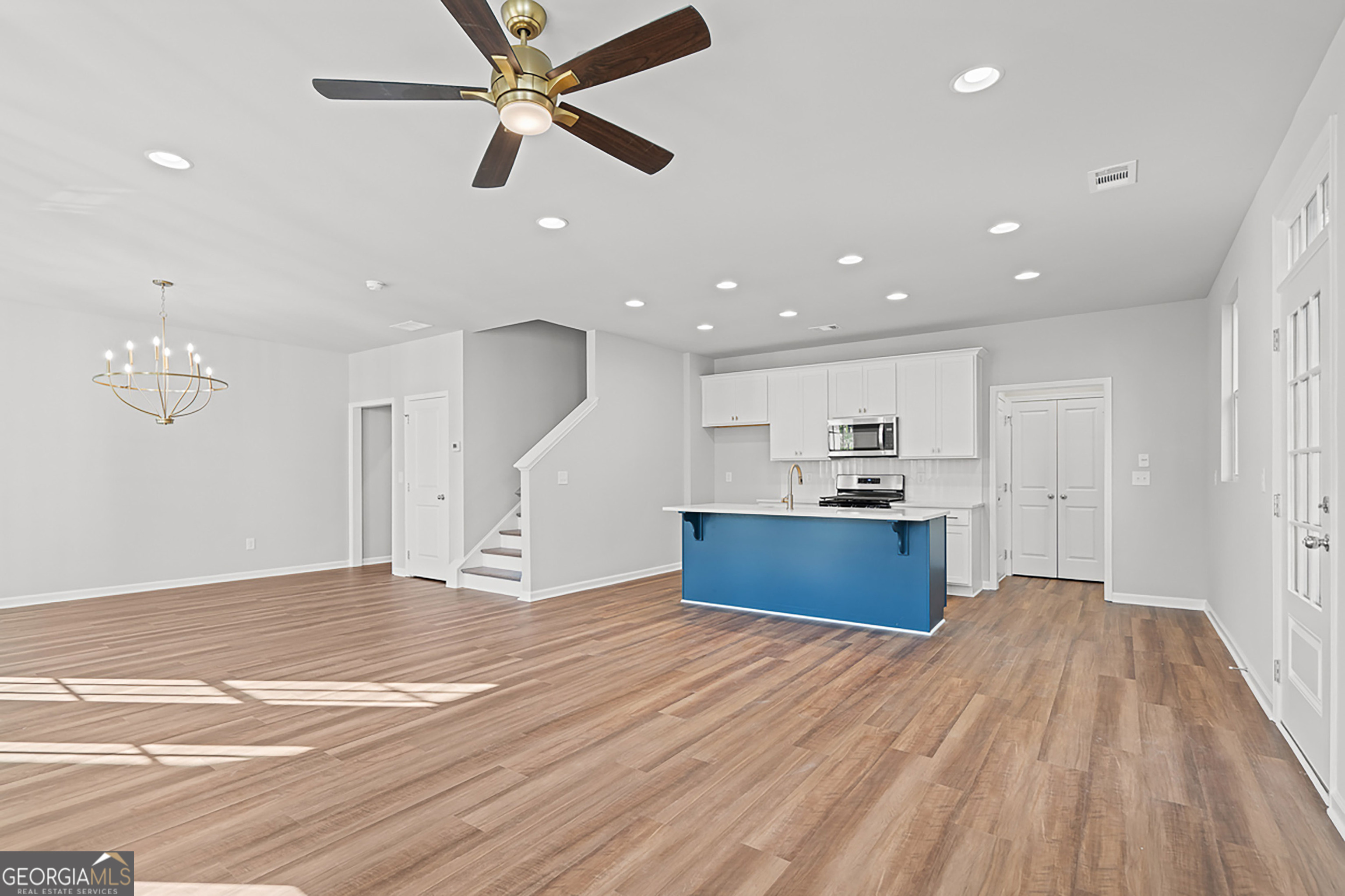 41 Hydrangea Lane, Unit 73 Auburn, GA 30011 - Photo 6 of 30 a view of kitchen and empty room with wooden floor ceiling fan