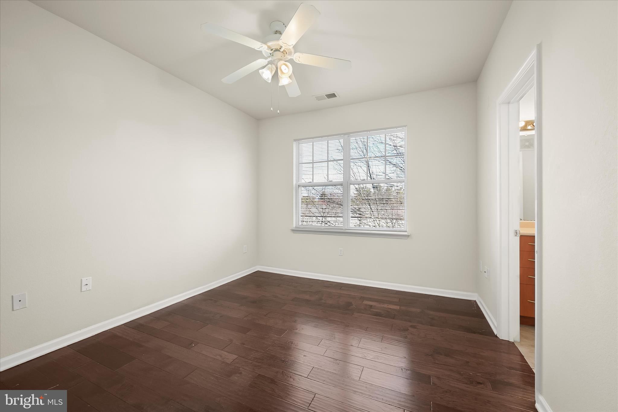19620 Galway Bay Circle, Unit 302 Germantown, MD 20874 - Photo 20 of 36 an empty room with wooden floor and windows