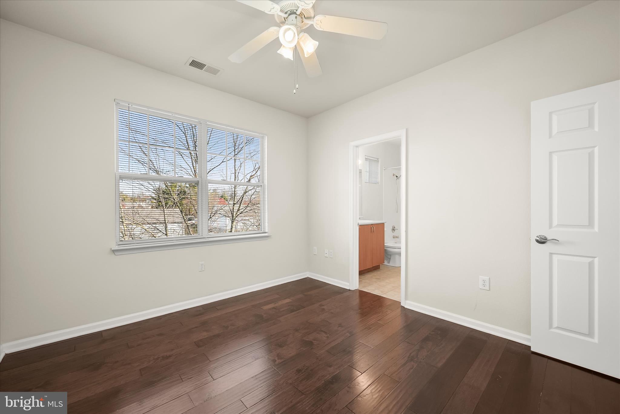 19620 Galway Bay Circle, Unit 302 Germantown, MD 20874 - Photo 21 of 36 a view of an empty room with wooden floor and window