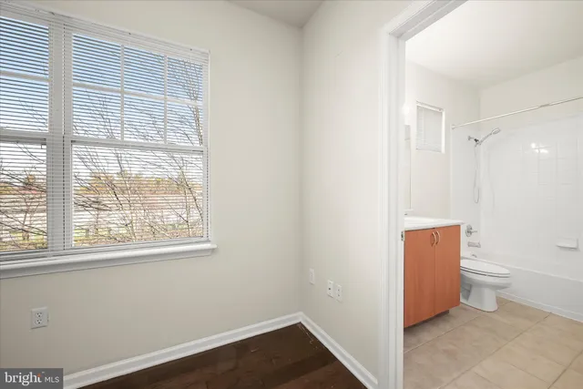 a view of a closet area with hardwood floor