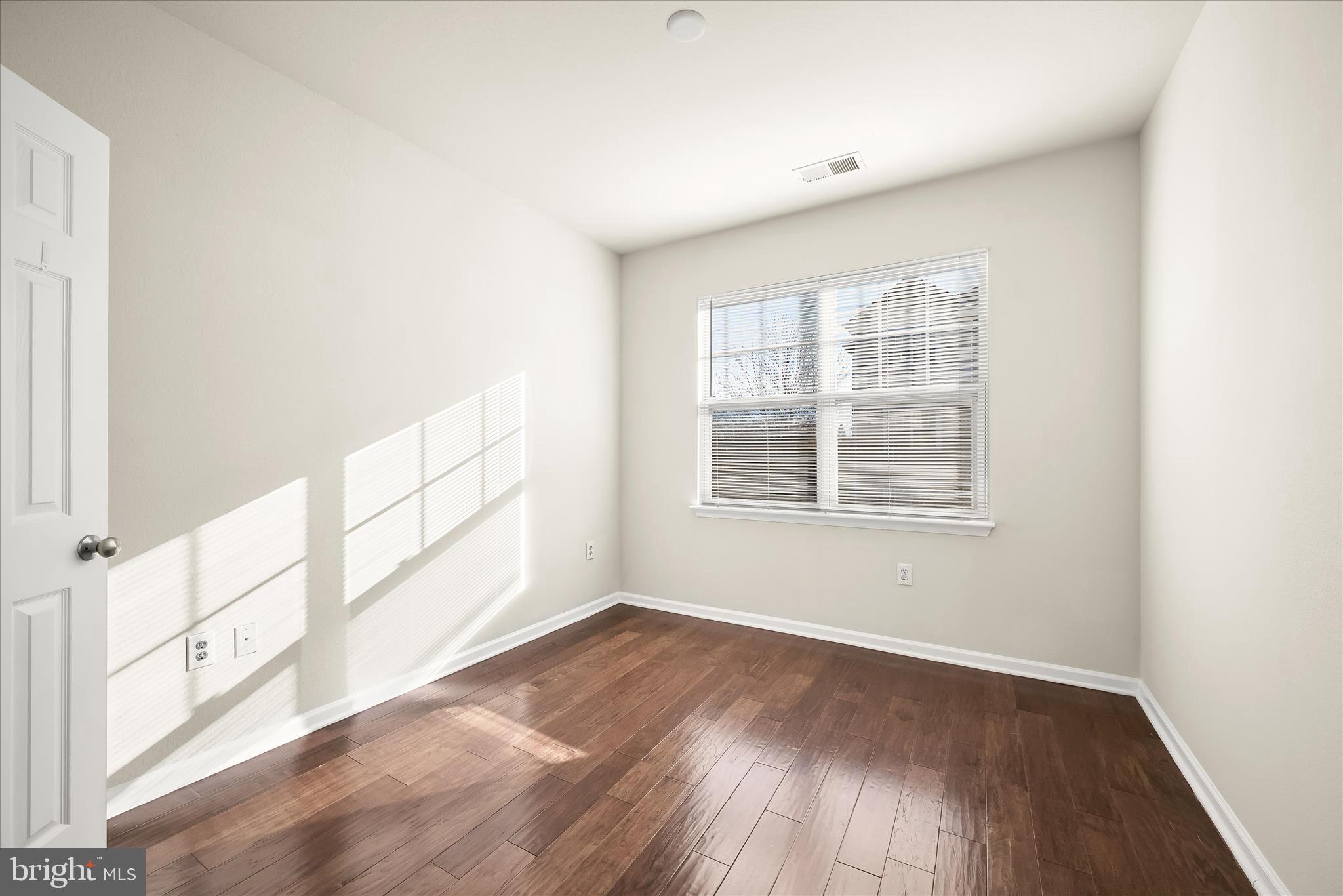 19620 Galway Bay Circle, Unit 302 Germantown, MD 20874 - Photo 25 of 36 an empty room with wooden floor and windows