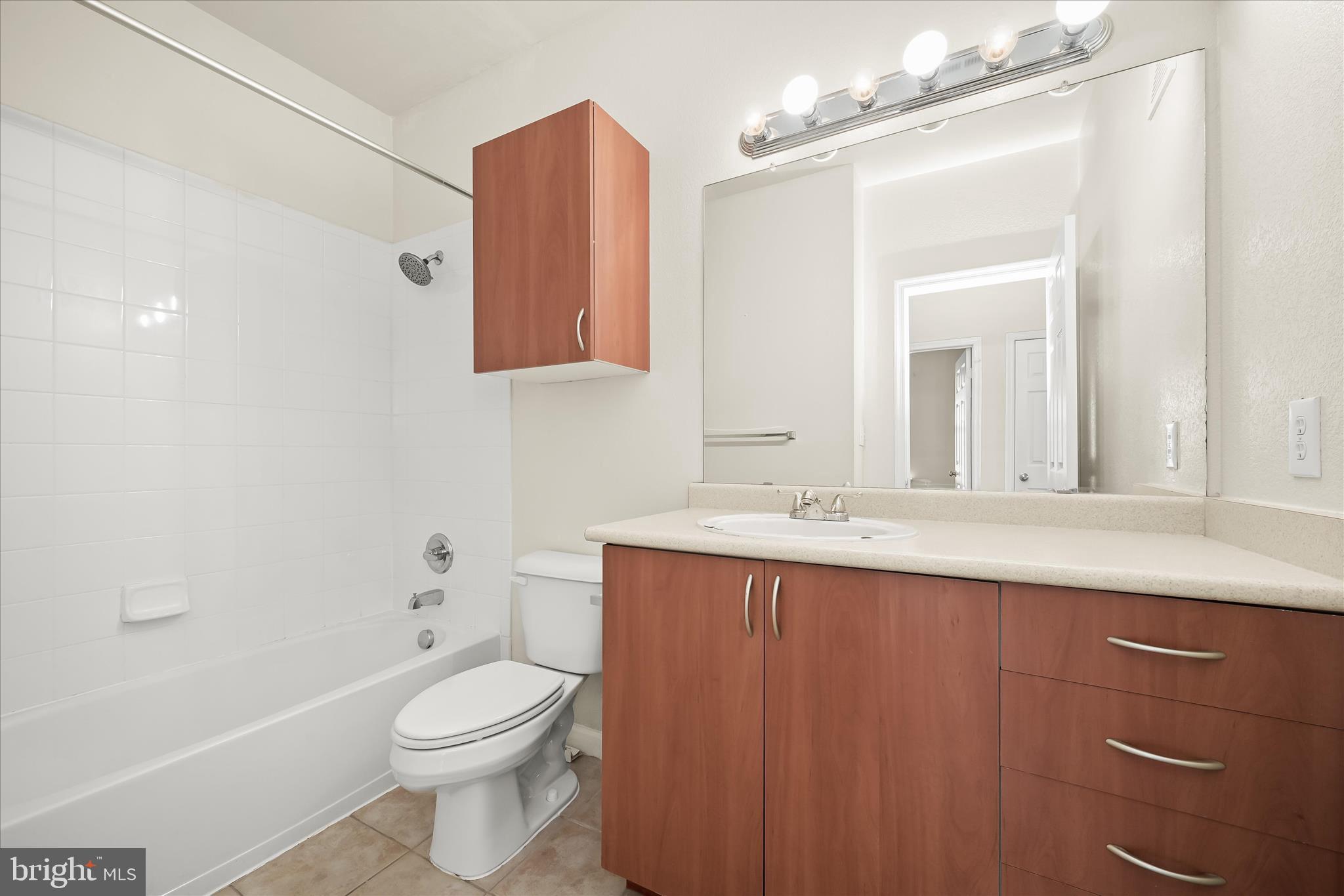 19620 Galway Bay Circle, Unit 302 Germantown, MD 20874 - Photo 28 of 36 a bathroom with a sink a toilet a mirror and vanity