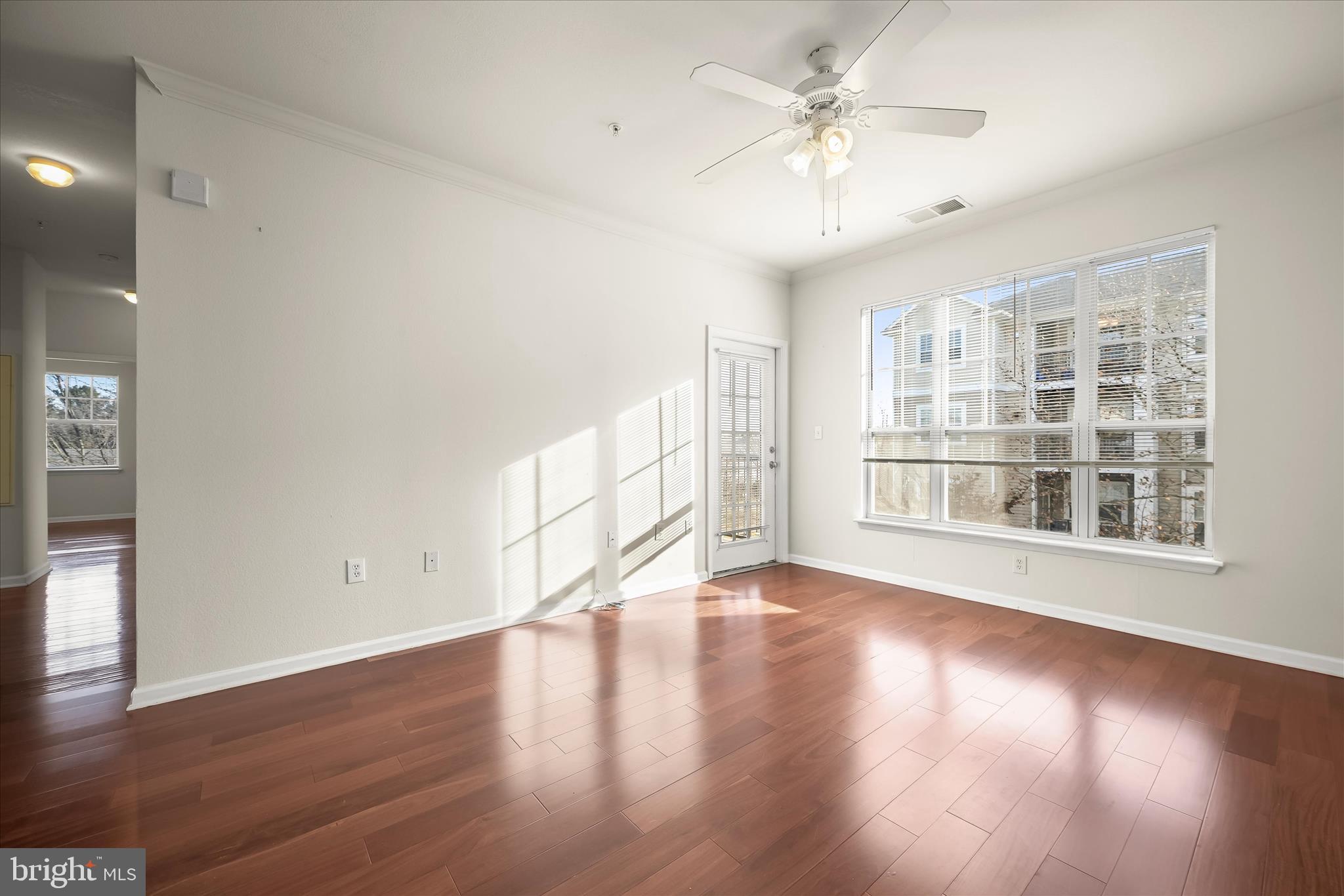 19620 Galway Bay Circle, Unit 302 Germantown, MD 20874 - Photo 8 of 36 wooden floor in an empty room with a window