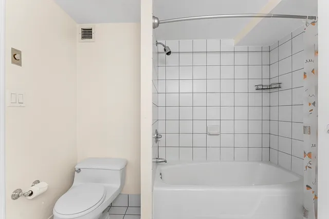 a white bath tub sitting next to a white toilet and a shower