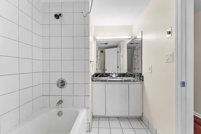 a bathroom with a granite countertop bathtub shower and sink