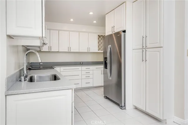 a kitchen with a refrigerator sink and cabinets
