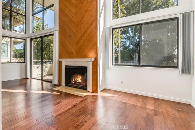 an empty room with wooden floor and a fireplace
