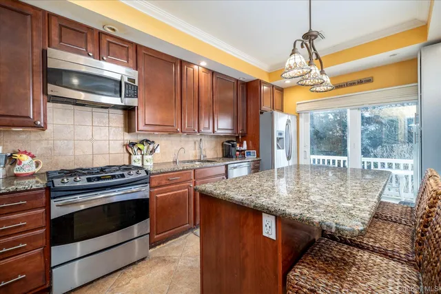 a kitchen with stainless steel appliances granite countertop a stove sink and cabinets