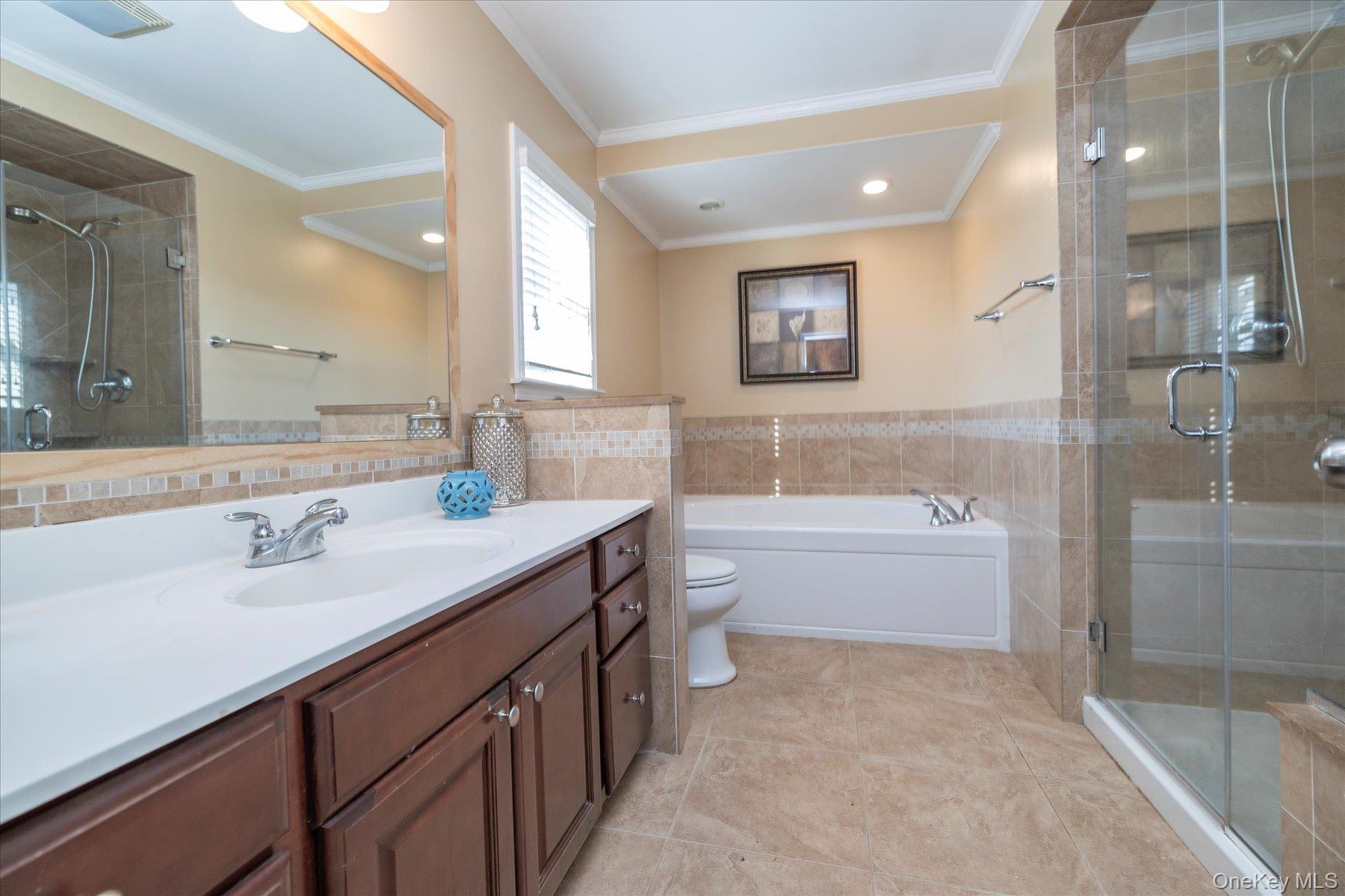84-24 252nd Street Queens, NY 11426 - Photo 13 of 24 a bathroom with a tub double sink window and a shower