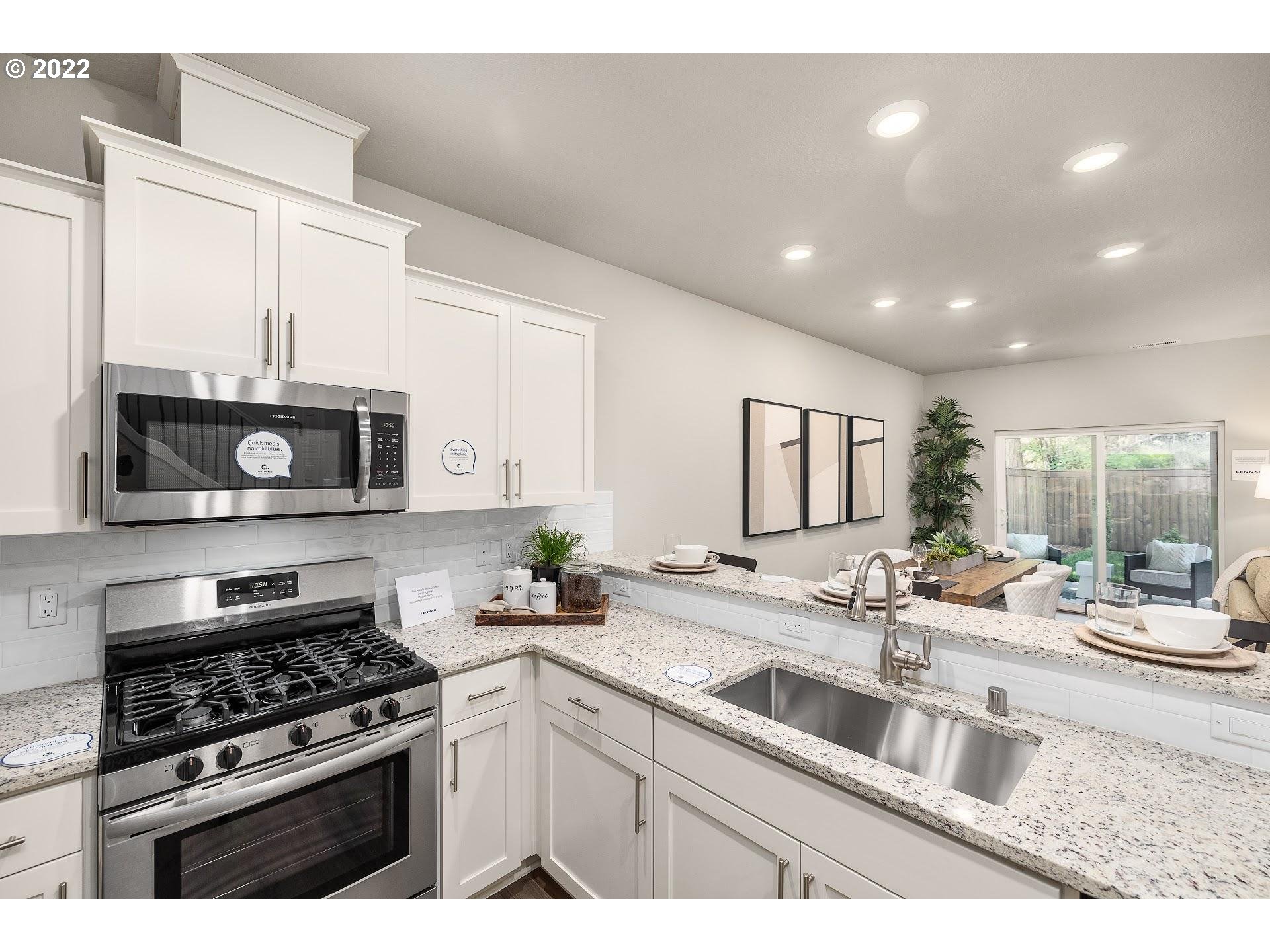 2420 South Brookside Place Ridgefield, WA 98642 - Photo 8 of 31 a kitchen with stainless steel appliances a sink a stove and microwave