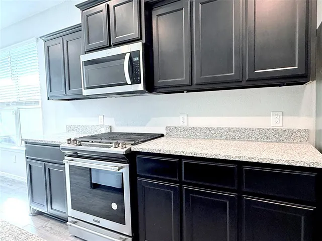 a kitchen with granite countertop cabinets stainless steel appliances and wooden cabinets