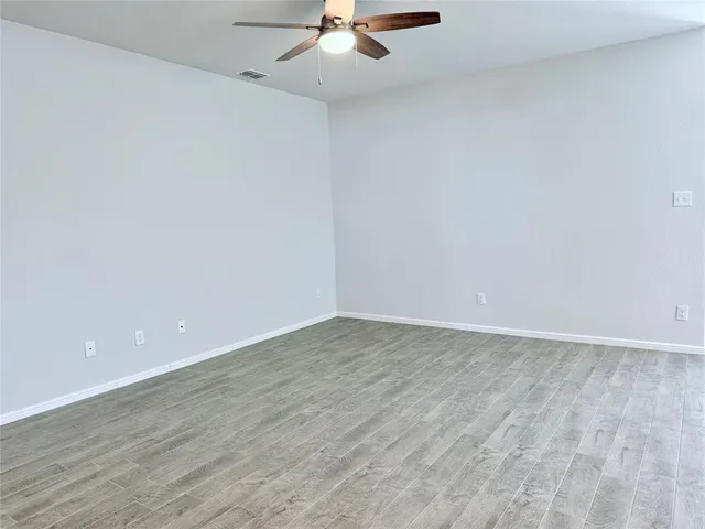 a view of an empty room with a ceiling fan