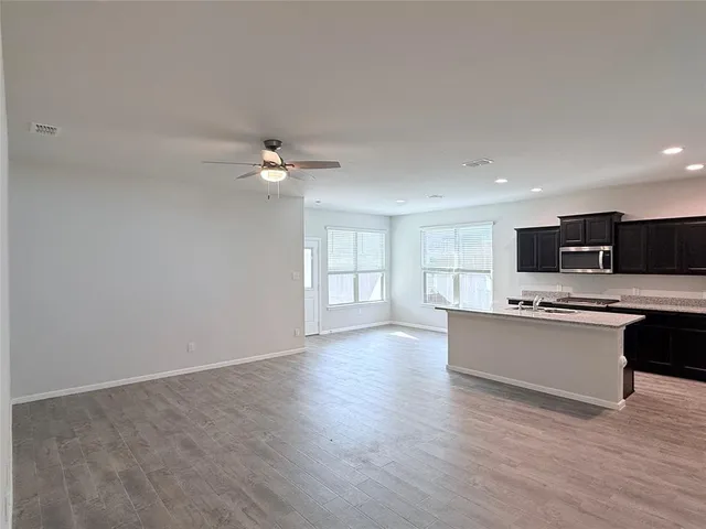 a view of kitchen with sink and refrigerator