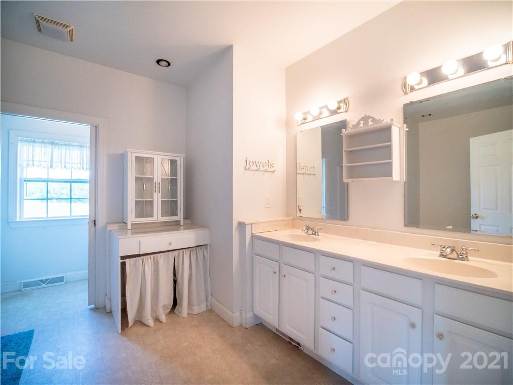 1807 John Shehan Road Mill Spring, NC 28756 - Photo 22 of 48 a spacious bathroom with double vanity a mirror a vanity and a shower