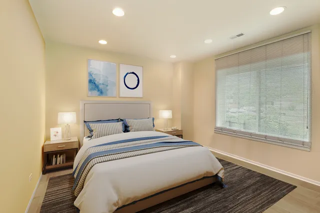 a bedroom with a bed flat screen tv and a window