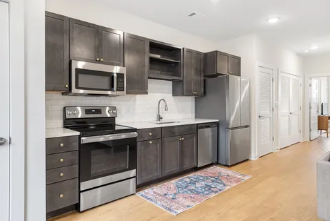 a kitchen with stainless steel appliances granite countertop a refrigerator and a stove top oven