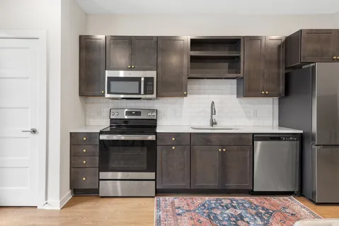 a kitchen with stainless steel appliances granite countertop a refrigerator stove and sink