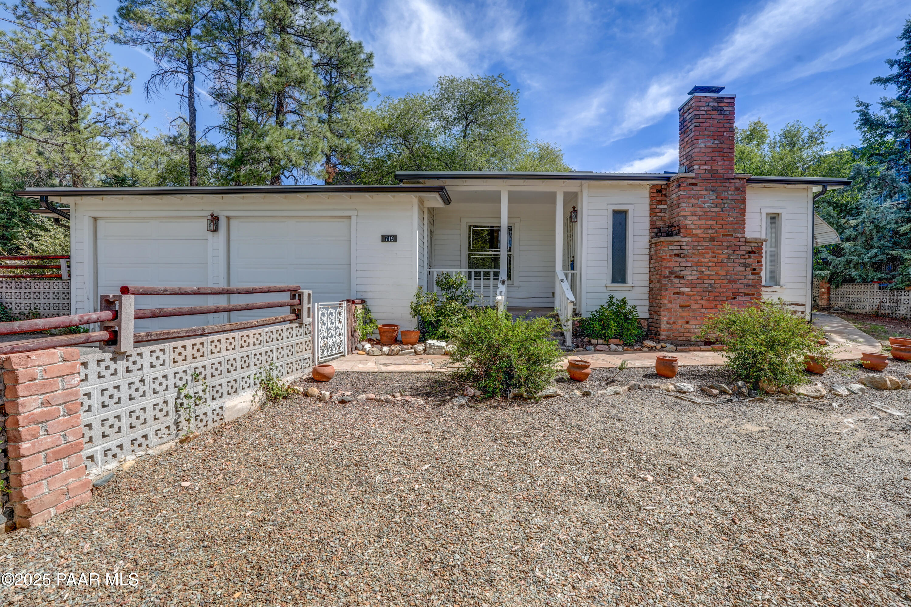 719 Pima Road Prescott, AZ 86303 - Photo 2 of 31 front view of a house with a large window and potted plants