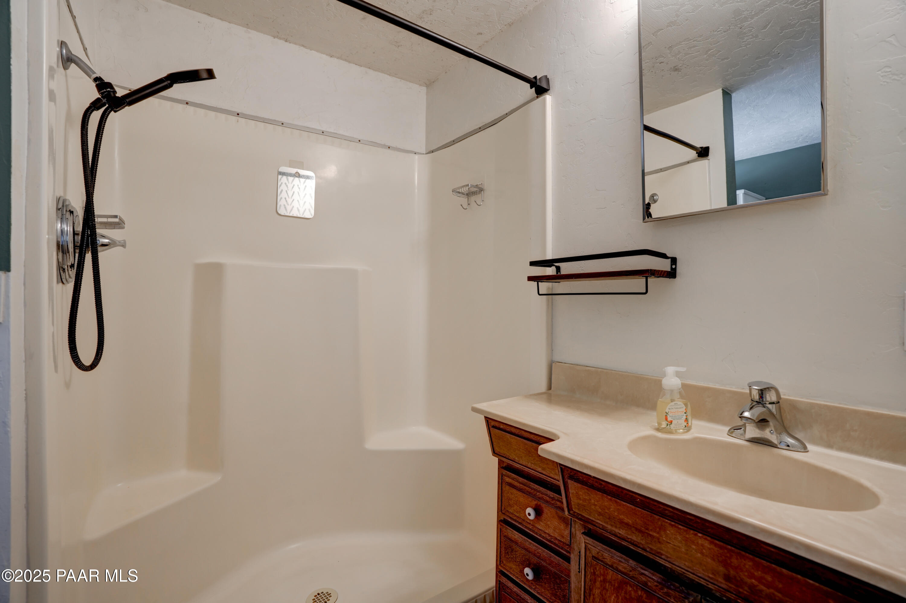 719 Pima Road Prescott, AZ 86303 - Photo 25 of 31 a bathroom with a granite countertop sink a mirror a vanity and shower