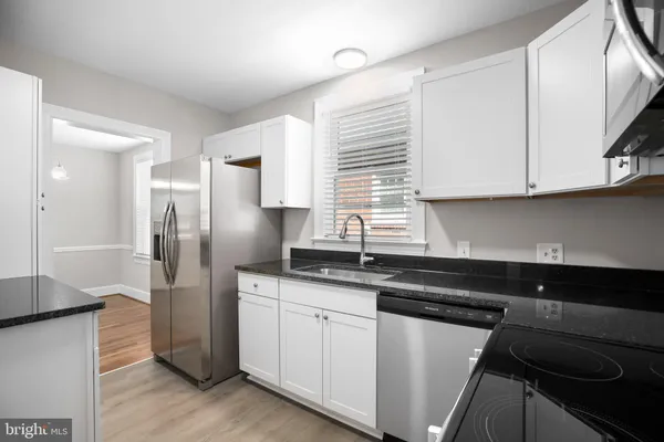 a kitchen with stainless steel appliances granite countertop a sink and a stove