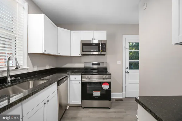 a kitchen with granite countertop a stove and a sink