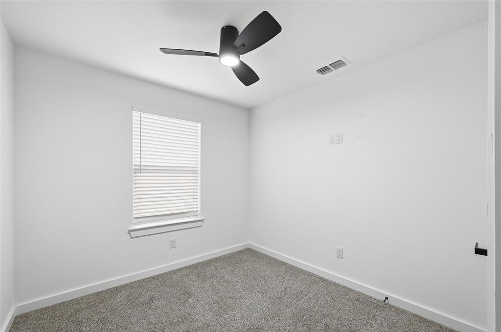 1311 Oneal Street, Unit B Commerce, TX 75428 - Photo 11 of 17 an empty room with windows and fan