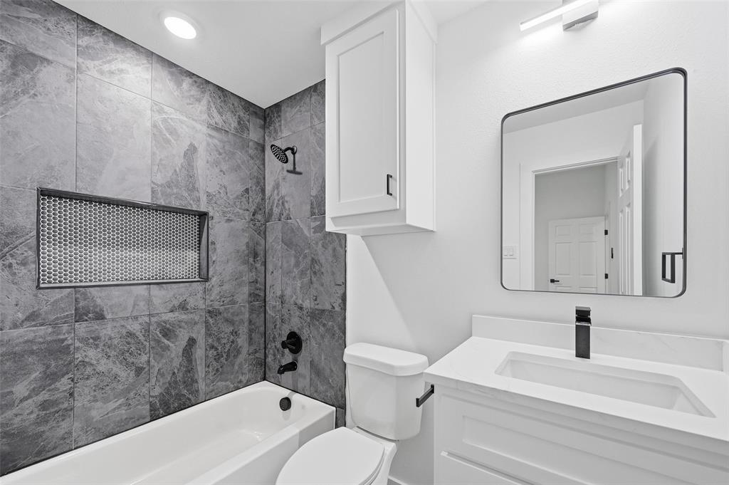 1311 Oneal Street, Unit B Commerce, TX 75428 - Photo 13 of 17 a bathroom with a sink a toilet and shower