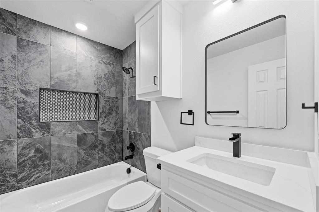 1311 Oneal Street, Unit B Commerce, TX 75428 - Photo 14 of 17 a bathroom with a sink a toilet and shower