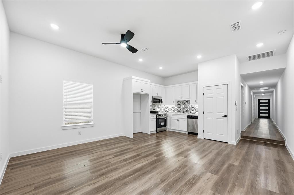 1311 Oneal Street, Unit B Commerce, TX 75428 - Photo 2 of 17 a view of a kitchen with center island wooden floor stainless steel appliances and cabinets
