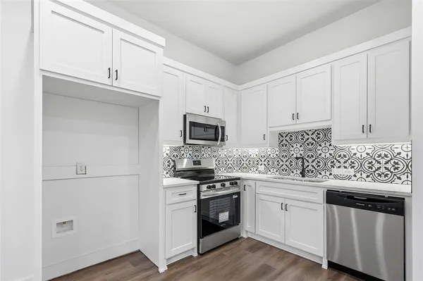 a kitchen with white cabinets and white appliances