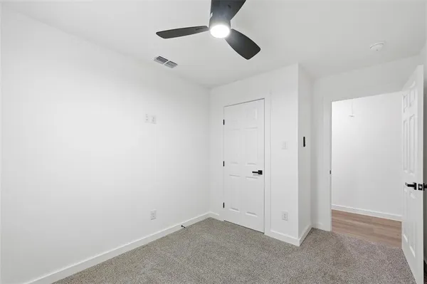 an empty room with chandelier fan