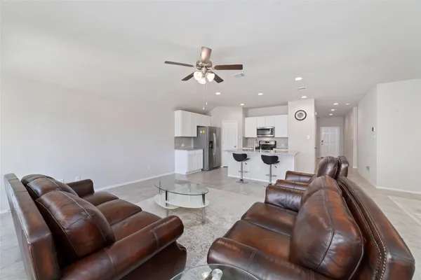 a living room with furniture kitchen view and a chandelier