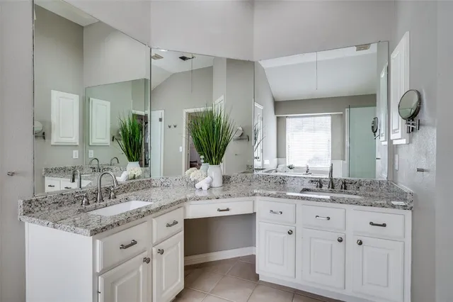a bathroom with a granite countertop sink double and mirror