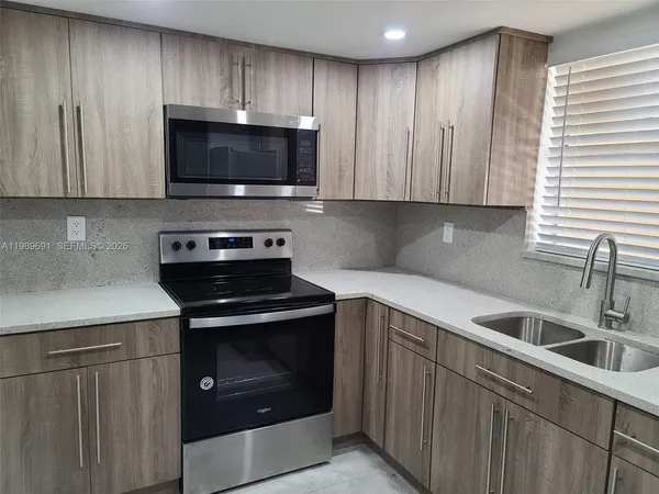 a kitchen with a sink and a stove top oven